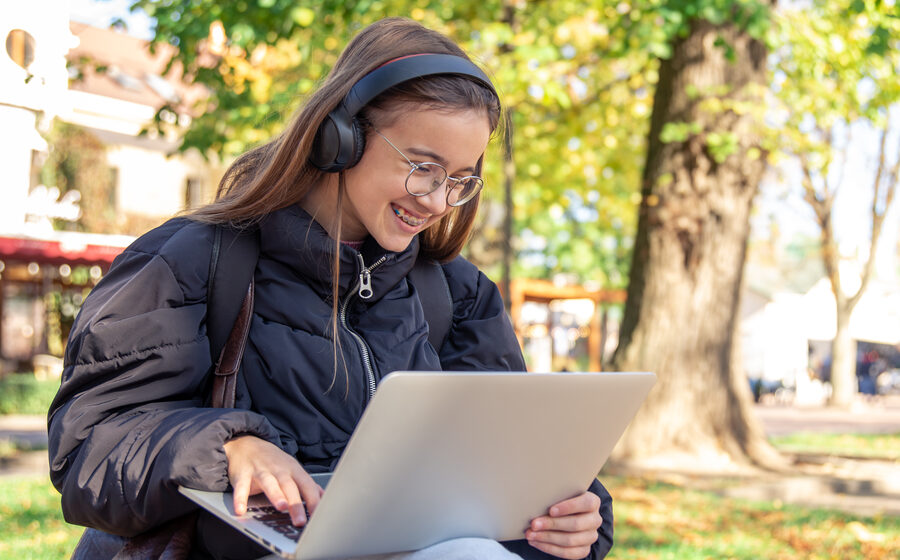 Estudiante practicando idiomas desde su laptop al aire libre